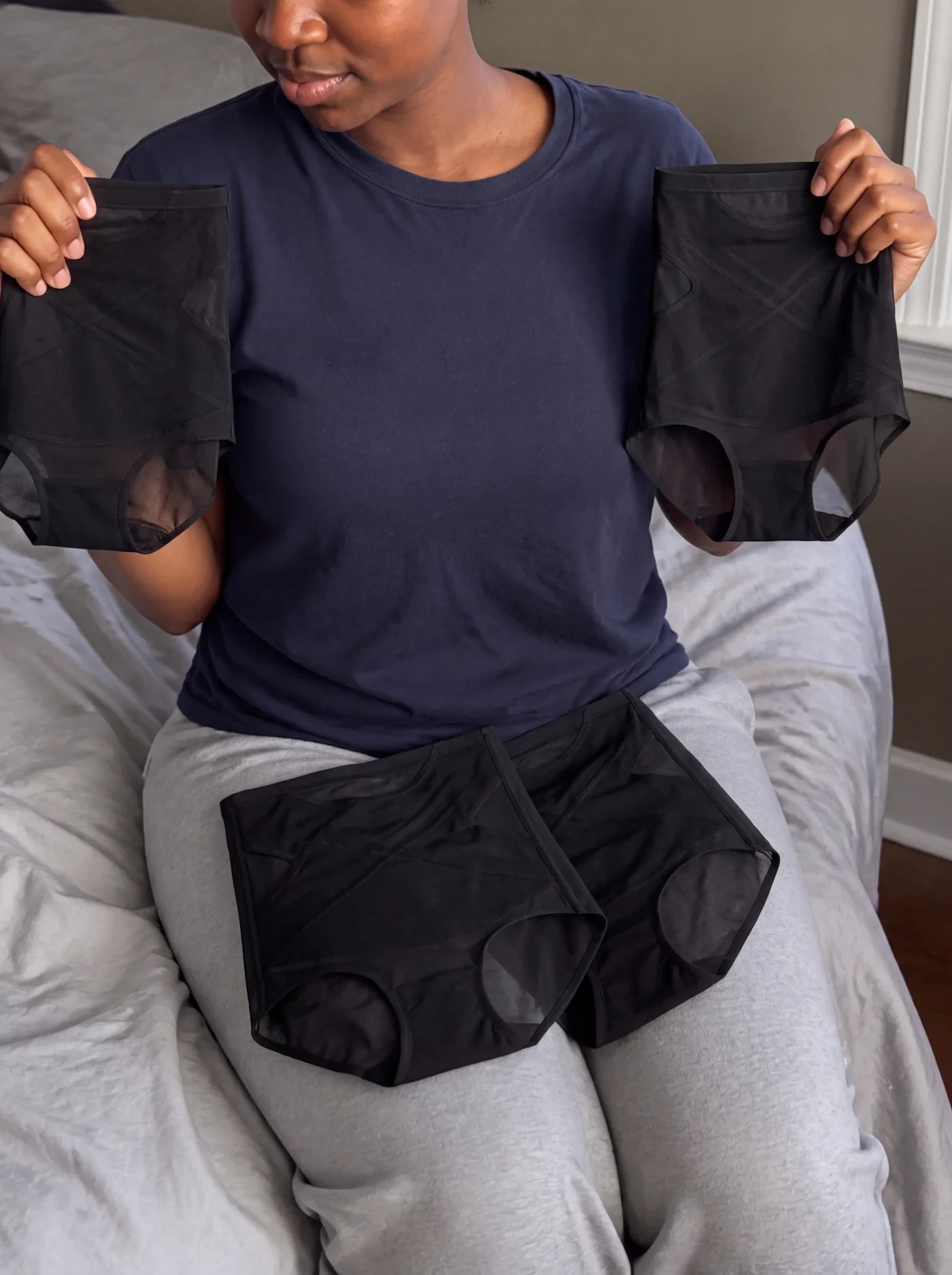 Customer holding five black NurtureForm X Matrix briefs