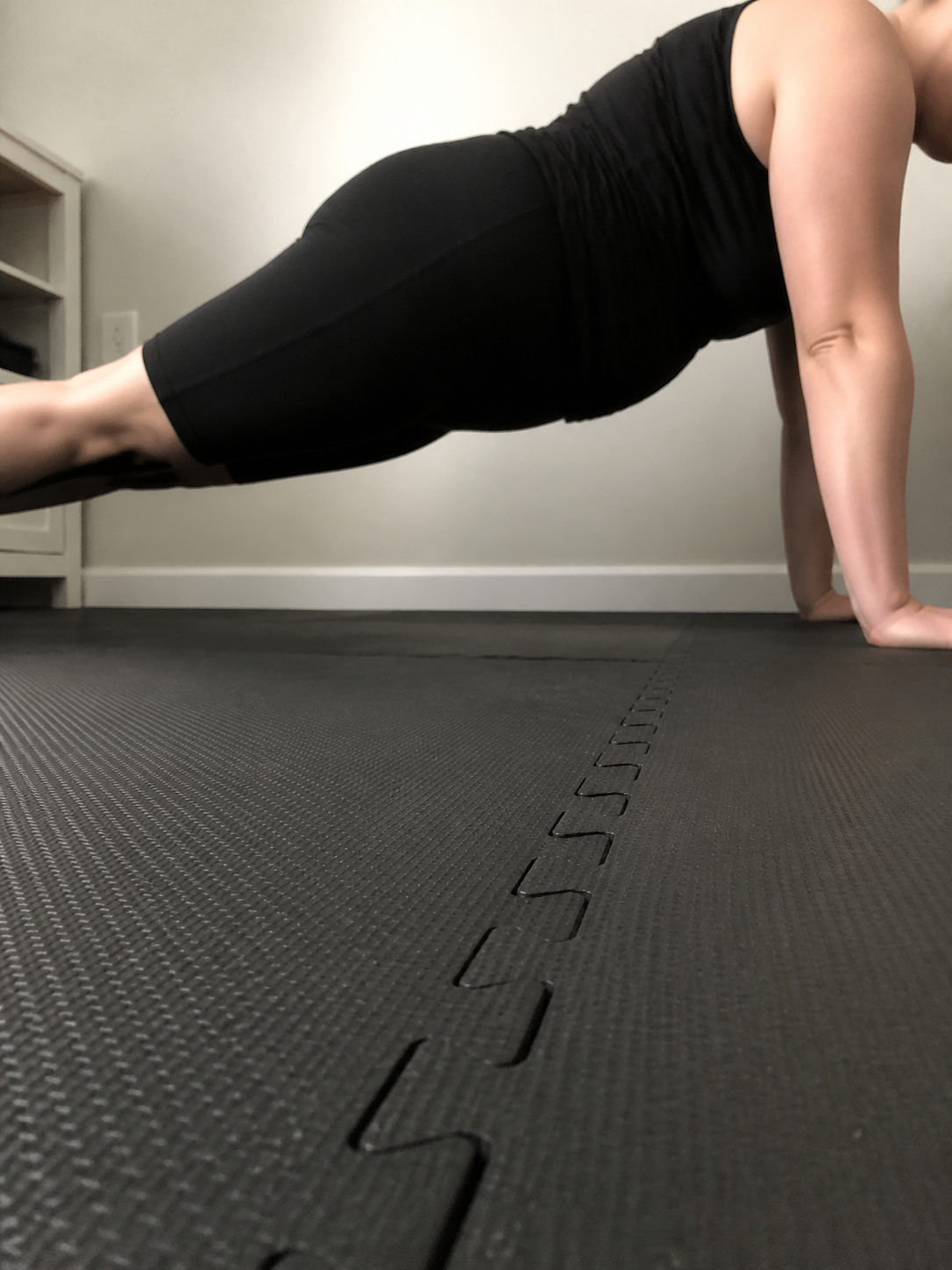 An adult woman holding a press-up position during a home workout
